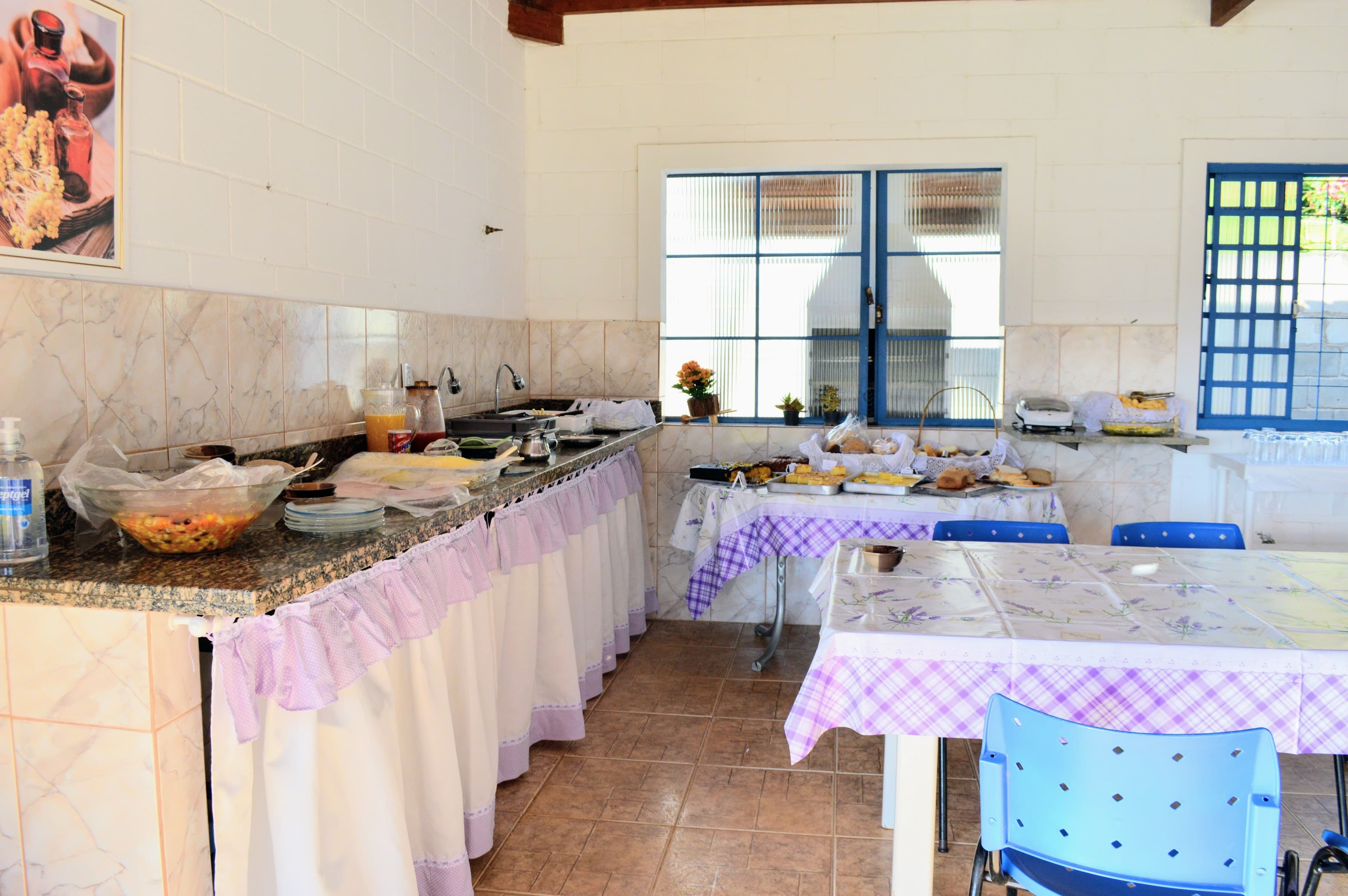 A mesa do café da manhã servido aos visitantes, com toalhas de lavanda.