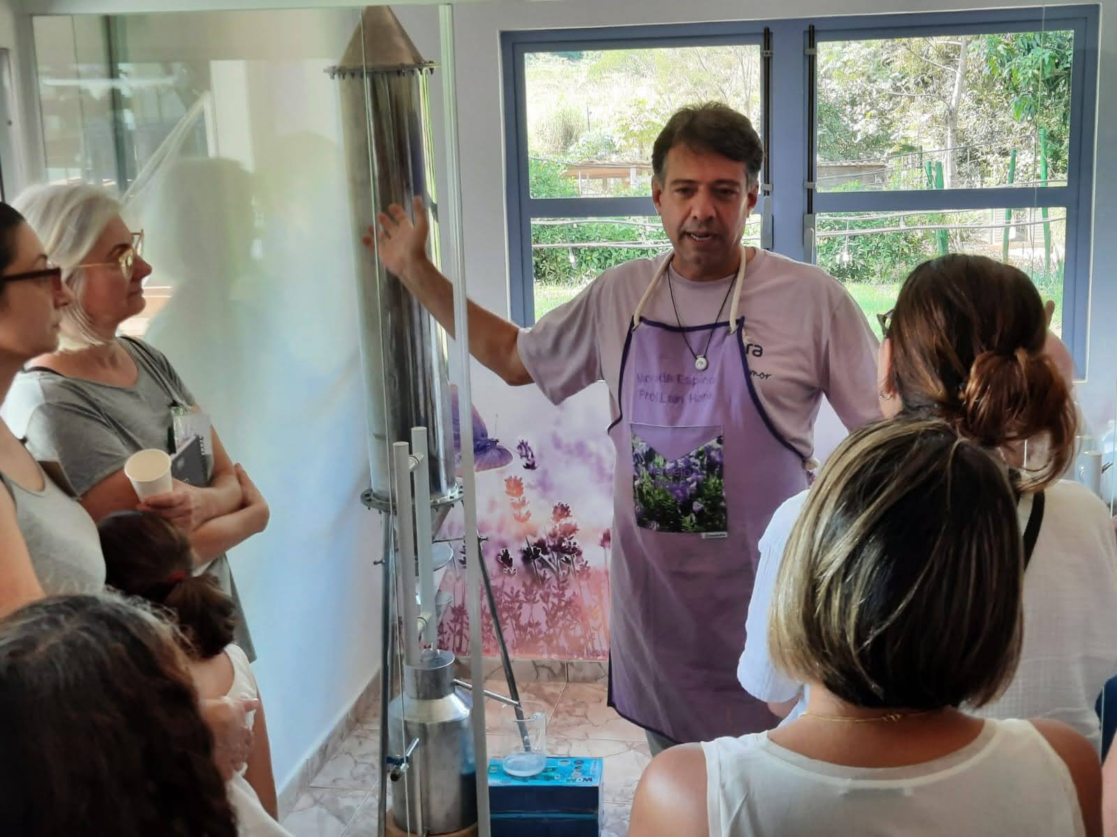 Guia explicando o funcionamento do alambique para o grupo de visitantes durante a destilação